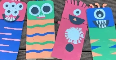 Cuatro monstruos de colores hechos con bolsas de papel